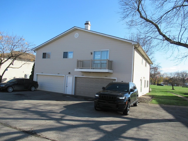 view of home's exterior featuring a balcony and a garage