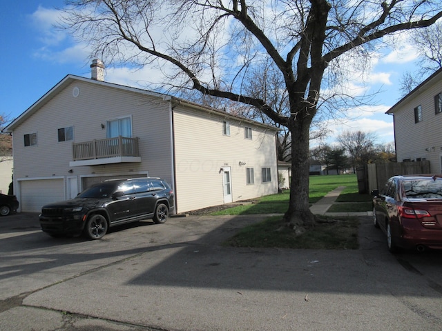 view of side of home with a balcony and a garage