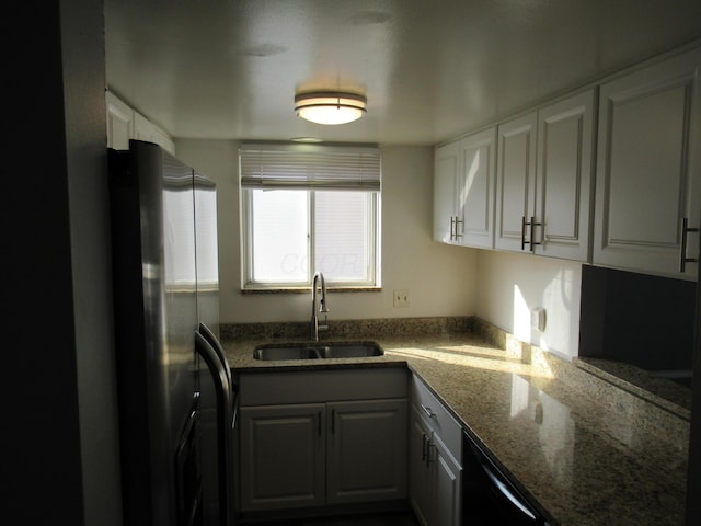 kitchen with dishwasher, stainless steel fridge, white cabinetry, and sink