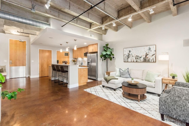 living room featuring a high ceiling and concrete floors