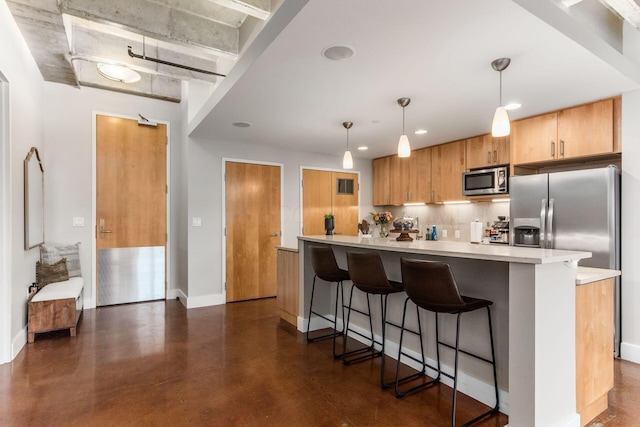 kitchen with a kitchen bar, tasteful backsplash, stainless steel microwave, and pendant lighting