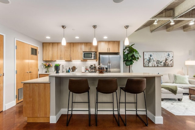 kitchen with a breakfast bar, pendant lighting, a center island, and stainless steel appliances