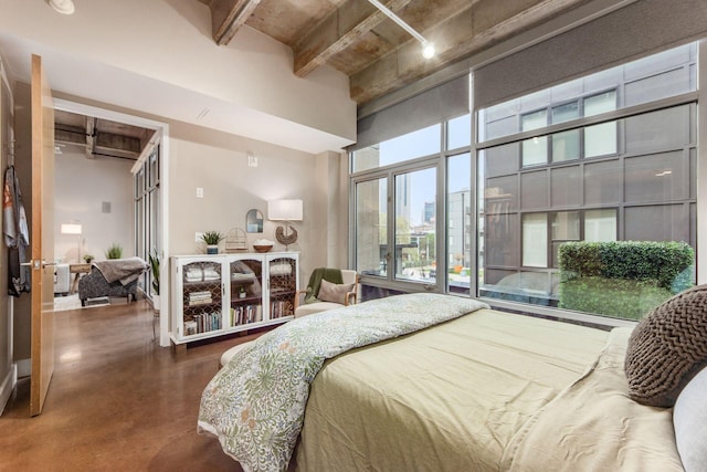 bedroom with beamed ceiling and concrete floors