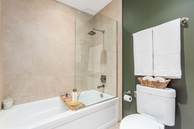 bathroom featuring toilet and shower / bath combination with glass door