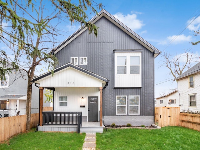 modern farmhouse style home with a porch and a front lawn