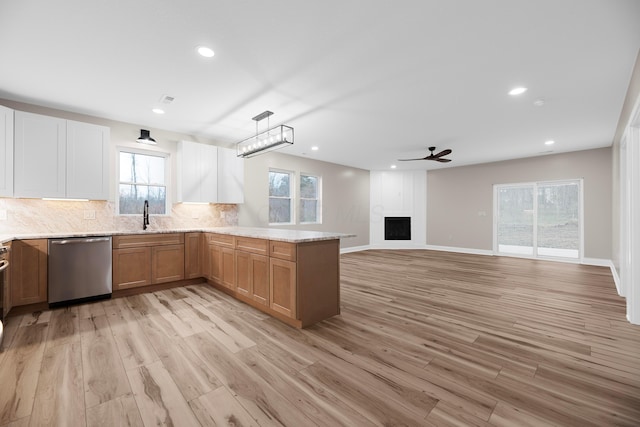 kitchen with sink, dishwasher, pendant lighting, and light wood-type flooring