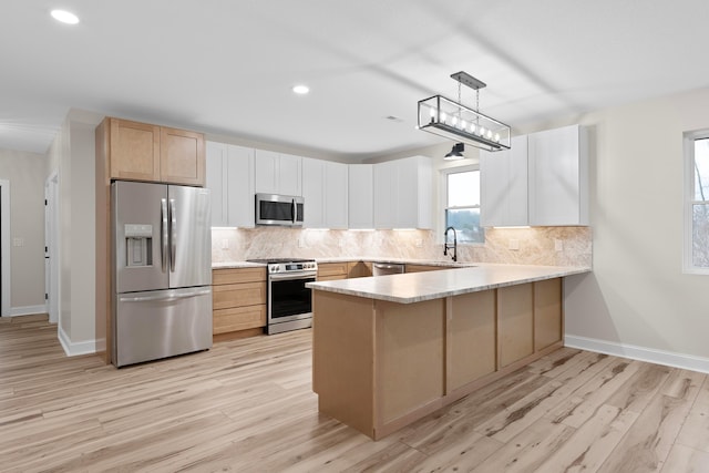 kitchen with pendant lighting, white cabinets, light hardwood / wood-style flooring, kitchen peninsula, and stainless steel appliances