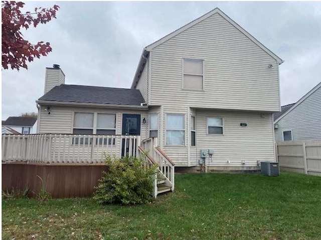 rear view of property with a yard and central air condition unit