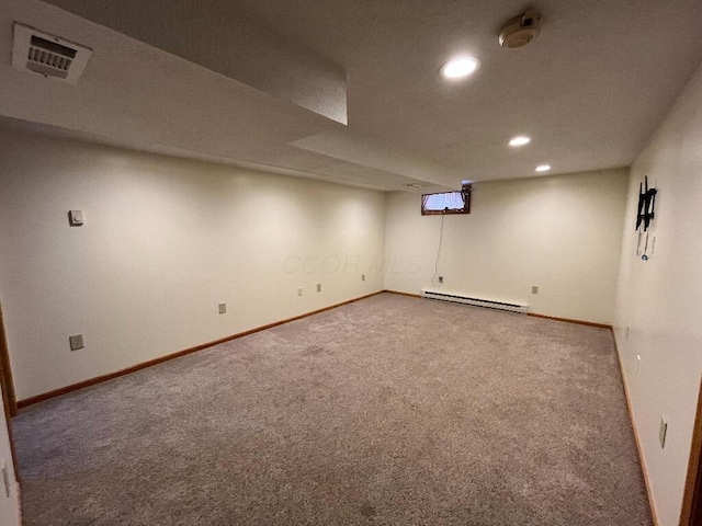 basement with a baseboard heating unit and carpet