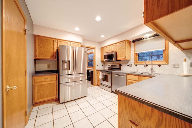 kitchen with stainless steel appliances, sink, light tile patterned floors, and backsplash