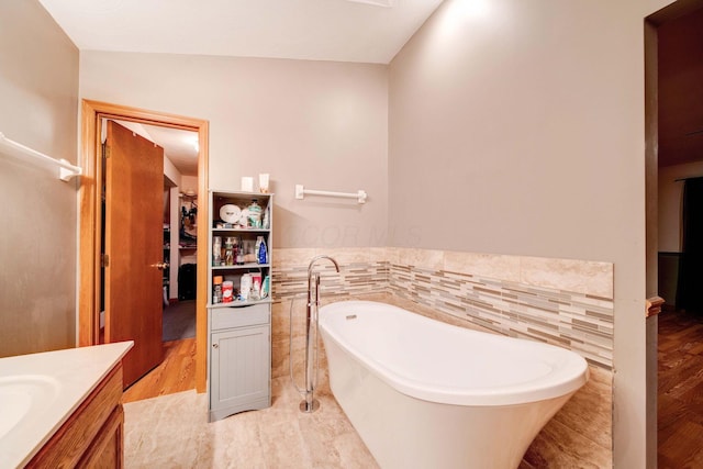 bathroom with vanity, tile walls, and a bathtub