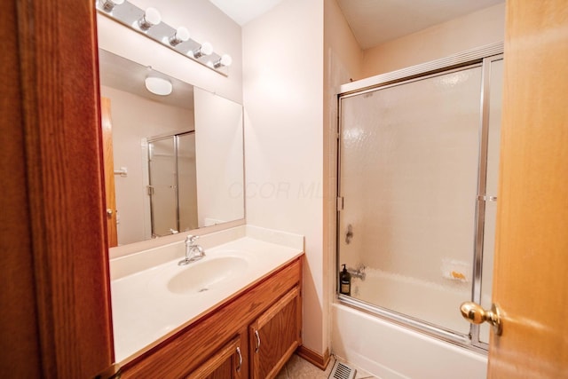 bathroom with vanity and bath / shower combo with glass door