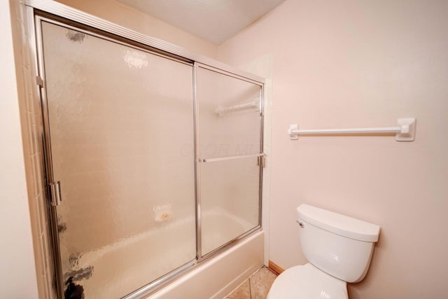 bathroom with tile patterned flooring, enclosed tub / shower combo, and toilet