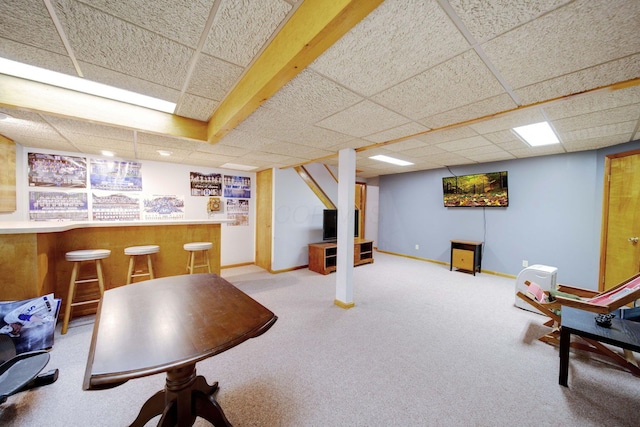 interior space featuring indoor bar, a paneled ceiling, and light carpet