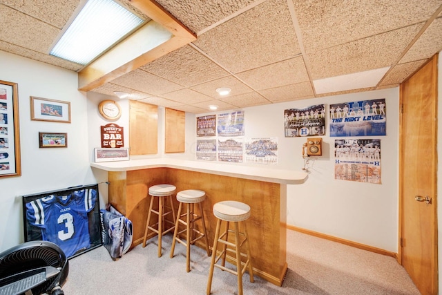 bar with a drop ceiling and carpet flooring