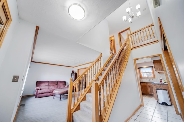 stairway featuring tile patterned floors and a chandelier