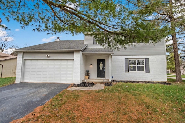 view of front of house with a front yard and a garage