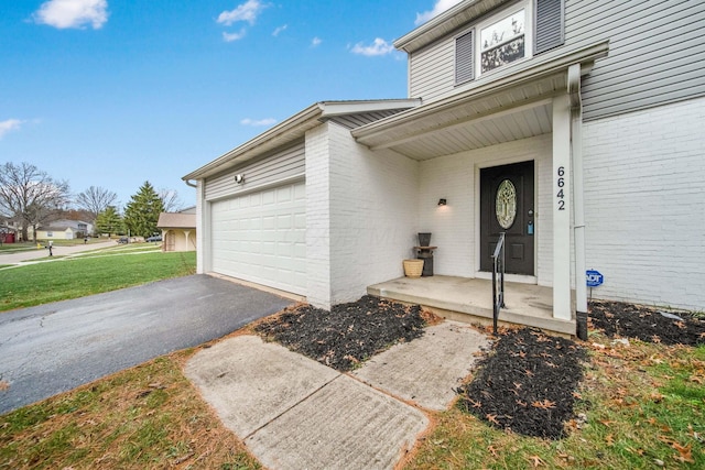 entrance to property with a lawn and a garage