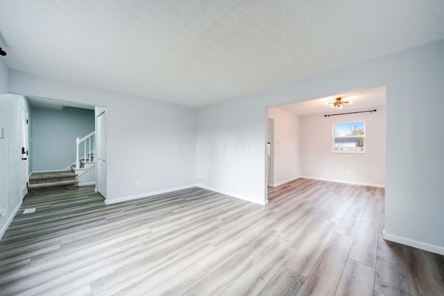 empty room featuring light hardwood / wood-style floors and a textured ceiling