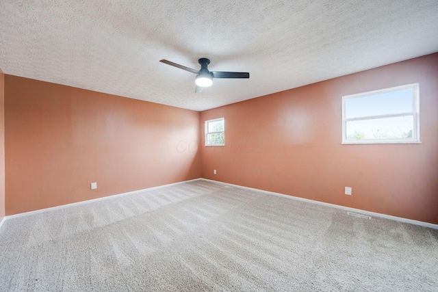 carpeted spare room with ceiling fan and a textured ceiling