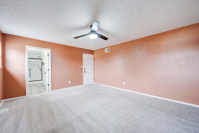 carpeted spare room with ceiling fan and a textured ceiling