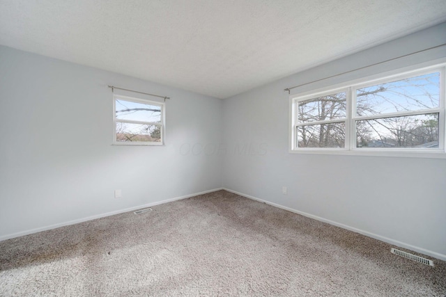 carpeted spare room featuring a textured ceiling