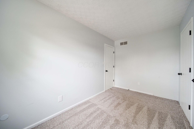 empty room featuring carpet and a textured ceiling