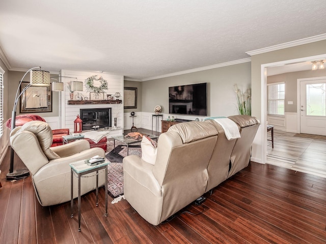 living room featuring a fireplace, dark wood-type flooring, and ornamental molding