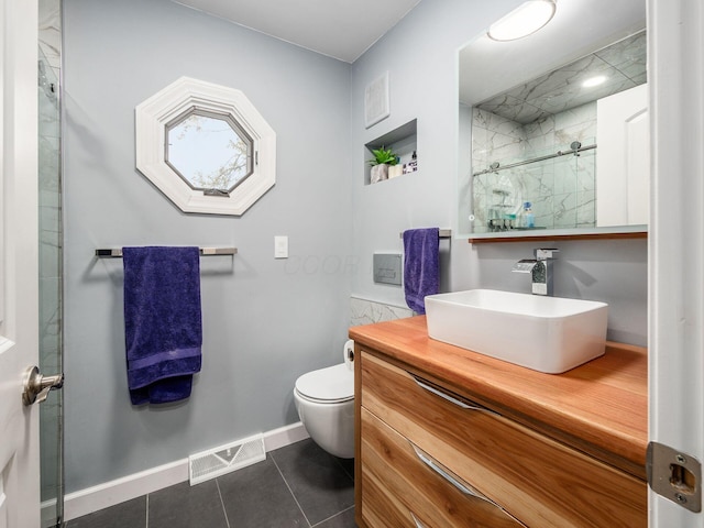 bathroom featuring tile patterned flooring, vanity, a shower with door, and toilet