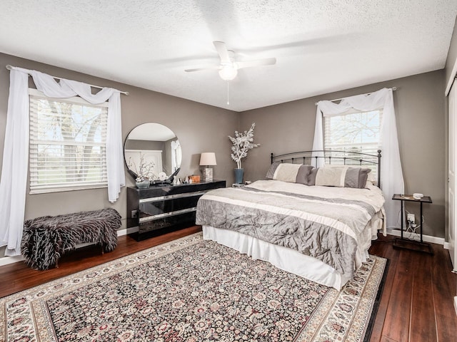 bedroom featuring ceiling fan, dark hardwood / wood-style floors, and a textured ceiling