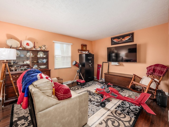 living room with a textured ceiling and dark hardwood / wood-style floors