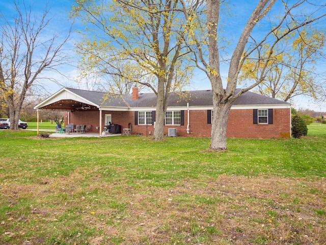 back of property with a lawn, a patio area, and central AC unit