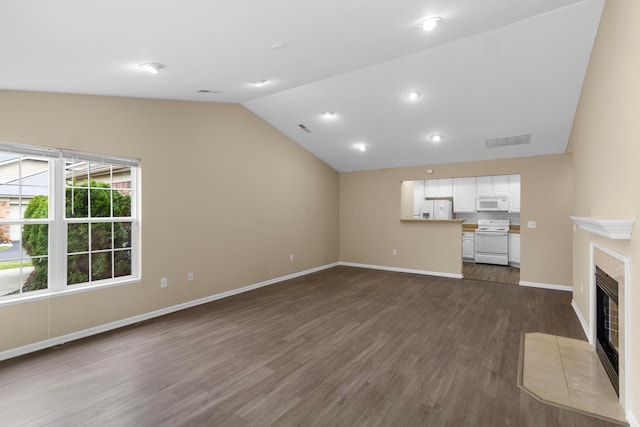 unfurnished living room with dark hardwood / wood-style flooring, vaulted ceiling, and a tiled fireplace