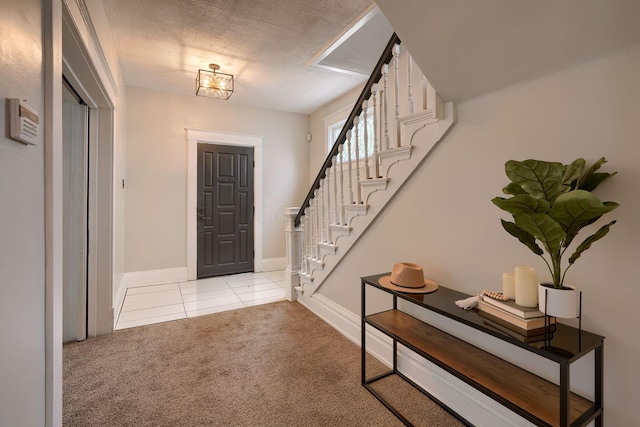 entryway with light colored carpet and a textured ceiling