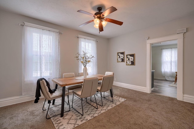 dining space featuring carpet and ceiling fan