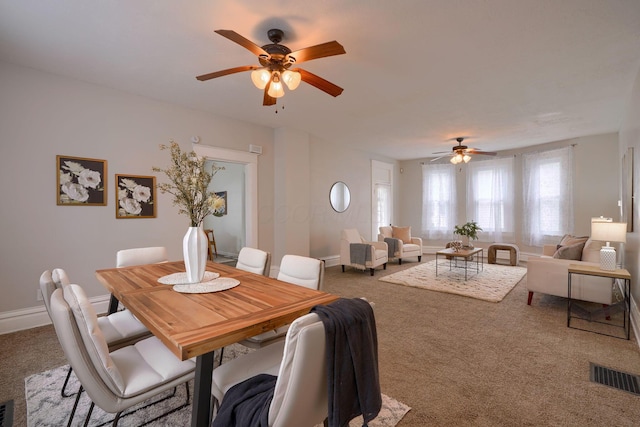 carpeted dining area with ceiling fan