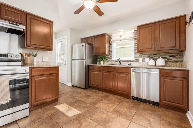 kitchen featuring ceiling fan, sink, tasteful backsplash, ventilation hood, and appliances with stainless steel finishes