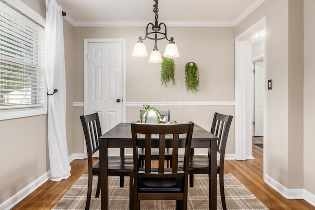 dining area with wood-type flooring and ornamental molding