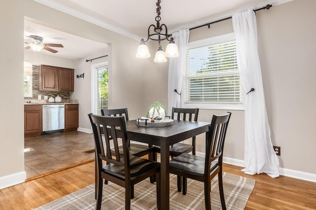 dining area featuring hardwood / wood-style floors, ceiling fan with notable chandelier, and crown molding