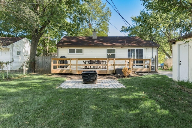 back of property with a lawn, a patio area, and a wooden deck