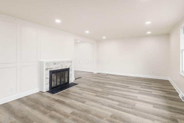 unfurnished living room with light hardwood / wood-style floors and a premium fireplace