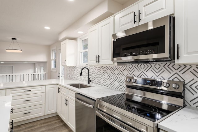 kitchen with hanging light fixtures, sink, dark hardwood / wood-style floors, appliances with stainless steel finishes, and white cabinetry