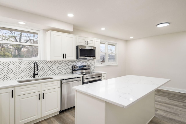 kitchen featuring a kitchen island, a healthy amount of sunlight, sink, and appliances with stainless steel finishes