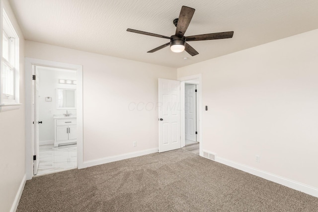 unfurnished bedroom with carpet flooring, ensuite bath, ceiling fan, and sink