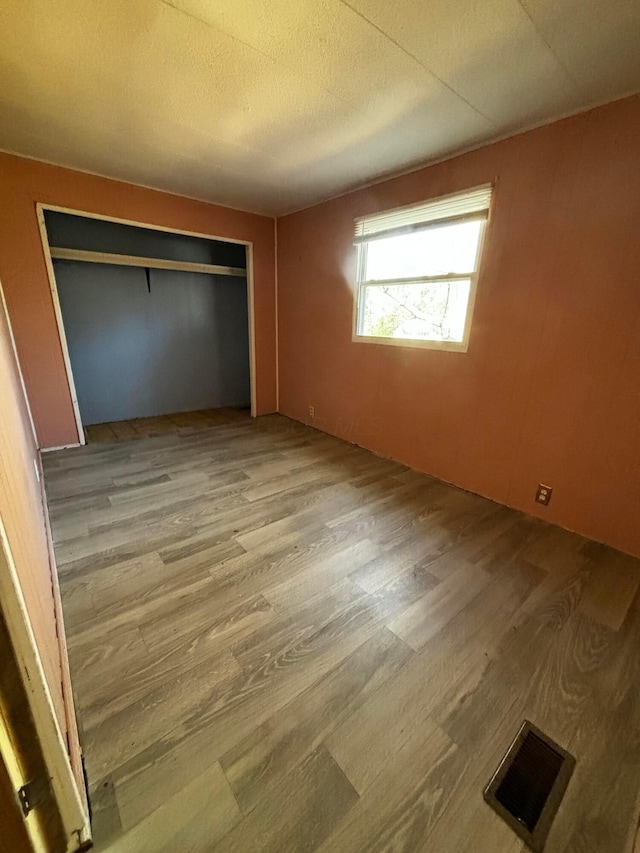 unfurnished bedroom featuring light hardwood / wood-style flooring and a closet