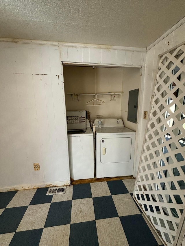 laundry room featuring independent washer and dryer, a textured ceiling, and electric panel