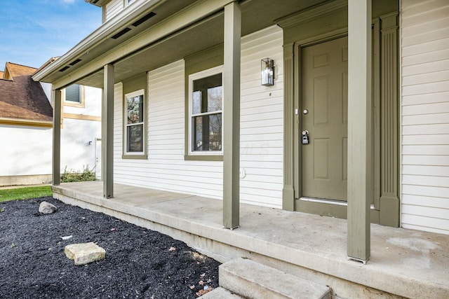 view of exterior entry featuring covered porch