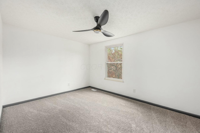 carpeted spare room featuring ceiling fan and a textured ceiling