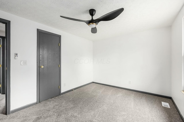 empty room featuring carpet, a textured ceiling, and ceiling fan