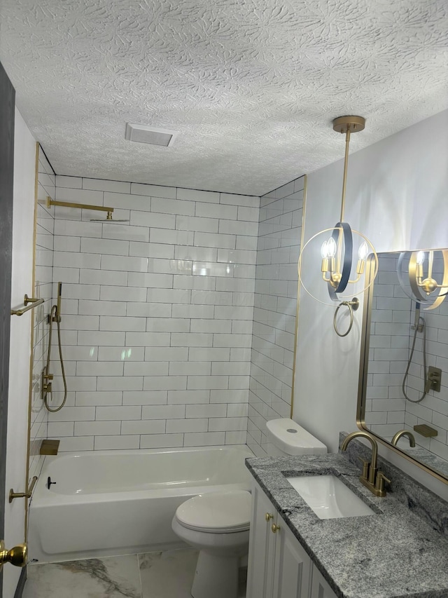 full bathroom featuring a textured ceiling, vanity, toilet, and tiled shower / bath